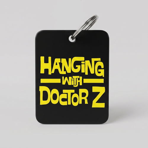 Black keychain with yellow text 'Hanging with Doctor Z' on a gray background